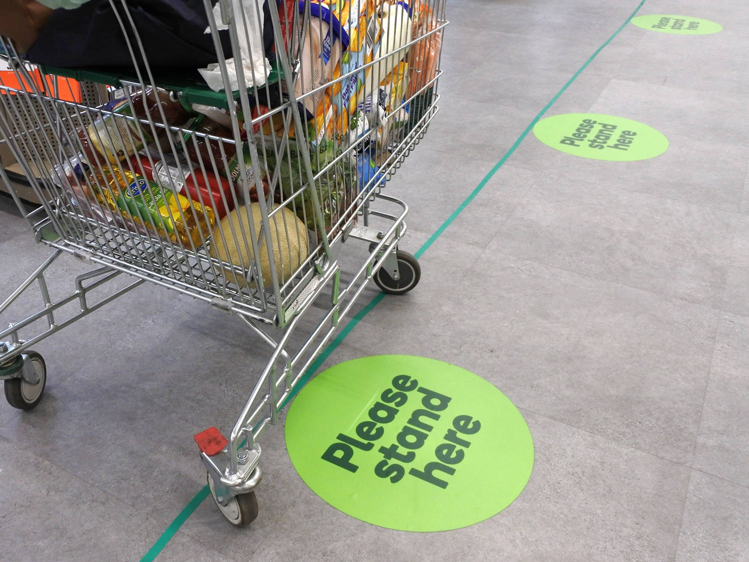 shopping cart in store with social-distancing markers